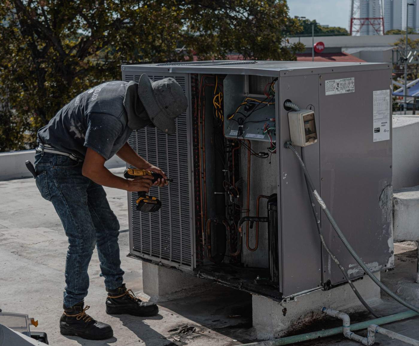 Technician servicing a rooftop AC unit